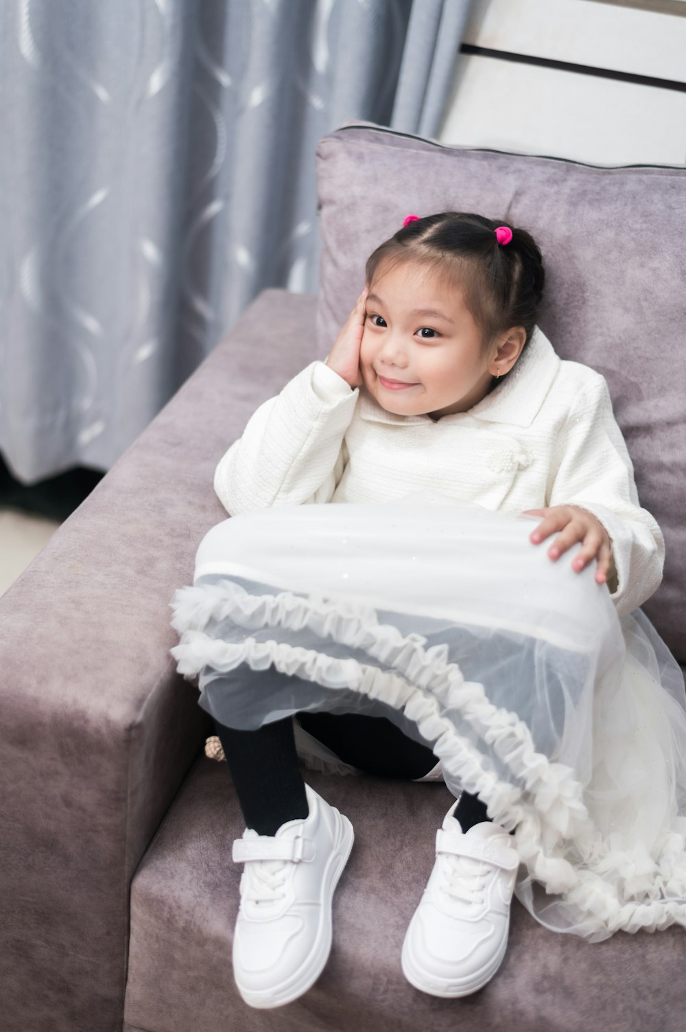 a little girl sitting on top of a couch