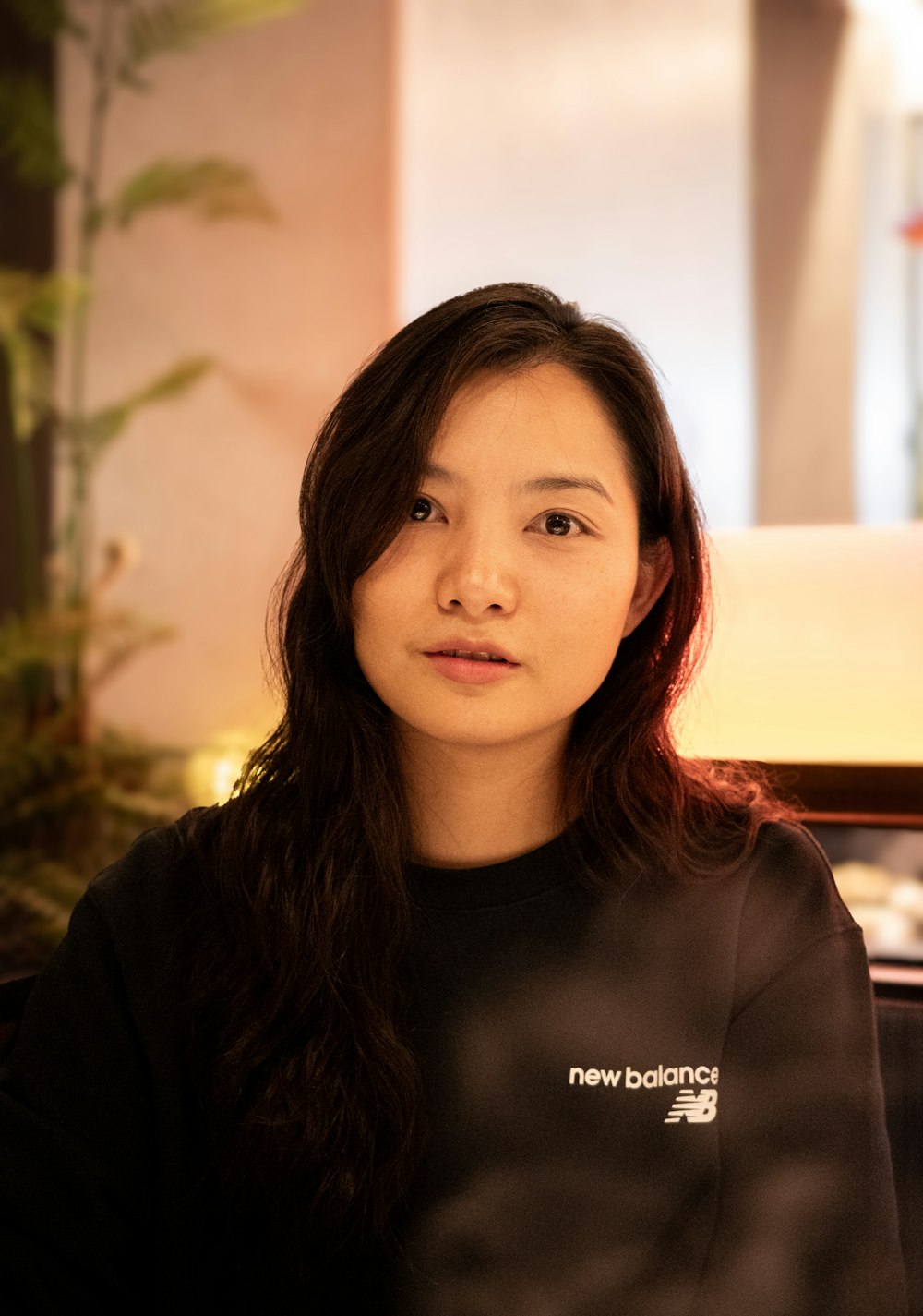 a woman with long hair wearing a new balance shirt