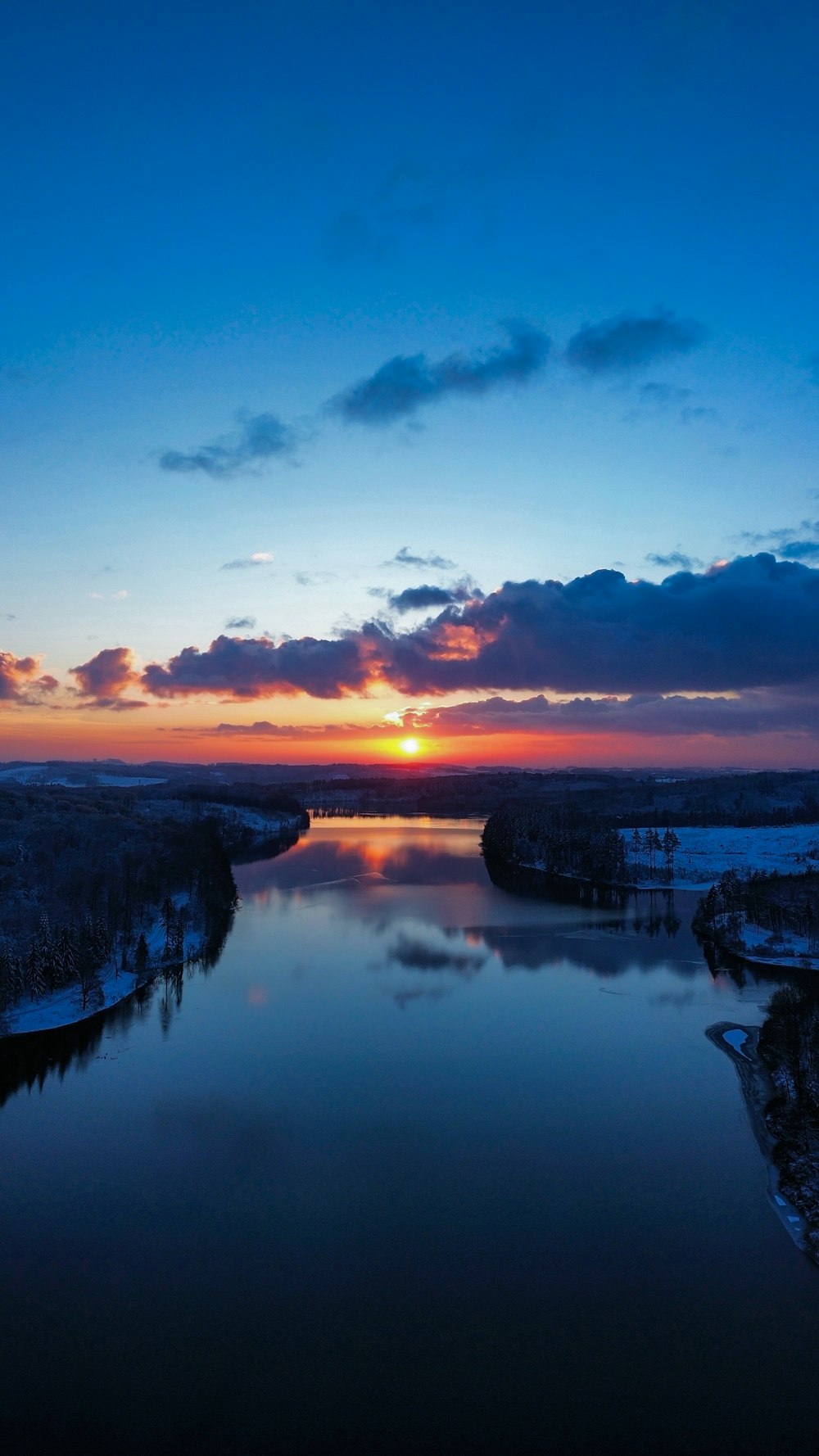 the sun is setting over the water in the middle of the day