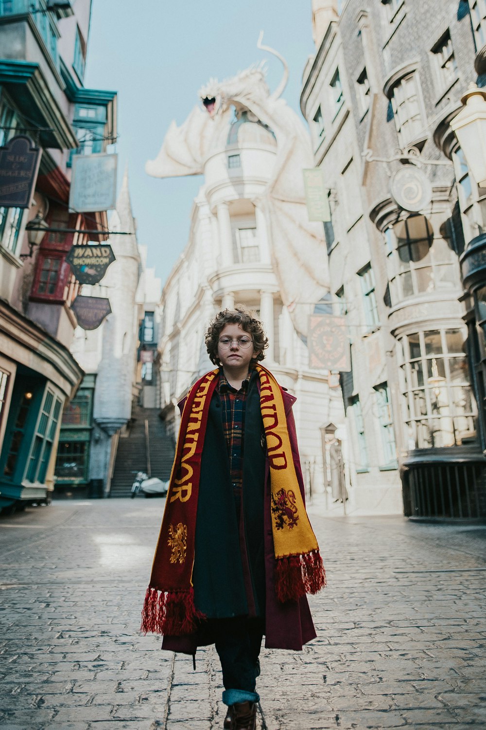 Un homme dans un costume de Harry Potter debout dans une rue de briques