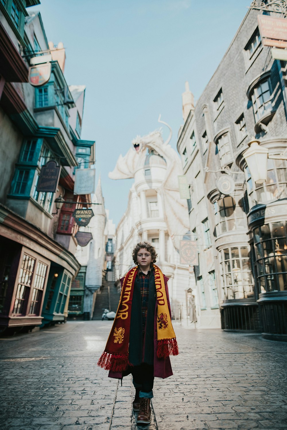 Ein Kind in einer Harry-Potter-Robe steht auf einer Backsteinstraße