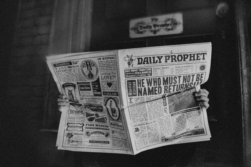 a person holding a newspaper in front of a doorway