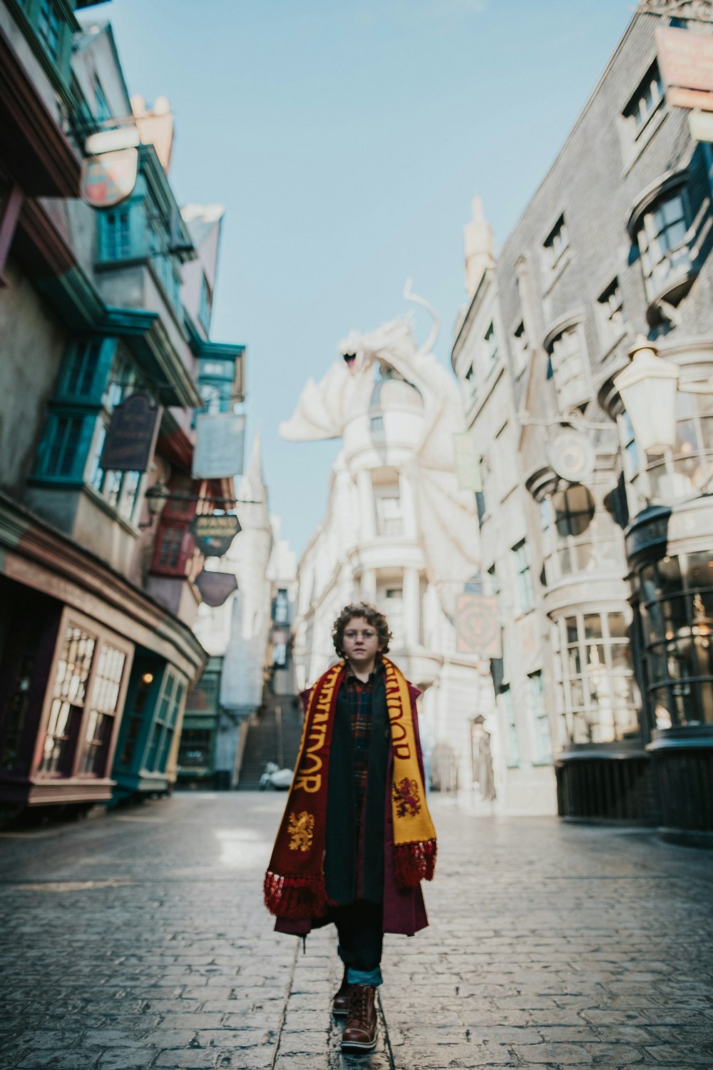 a woman in a harry potter robe standing on a brick street