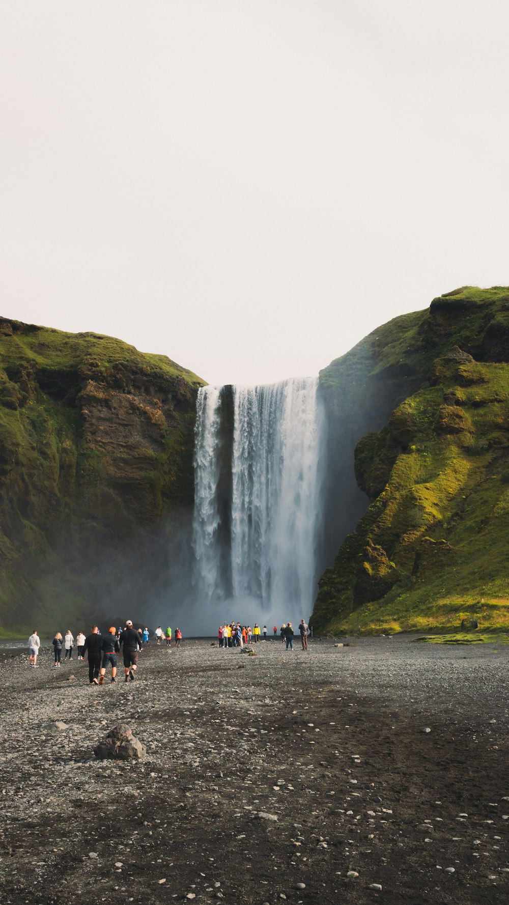 eine Gruppe von Menschen, die vor einem Wasserfall stehen