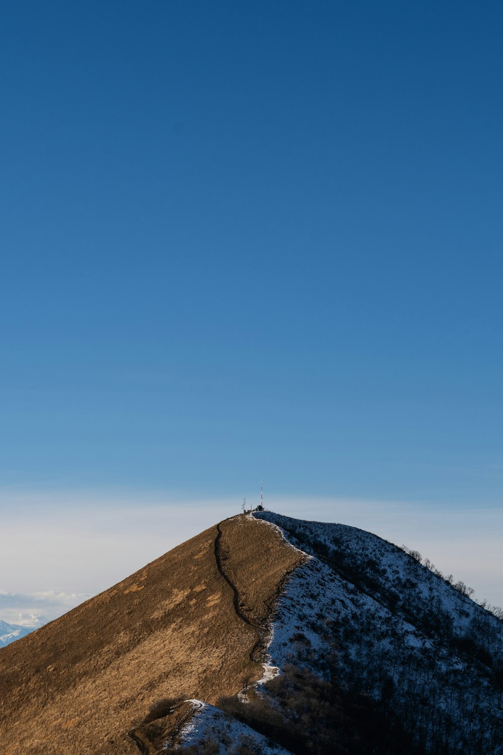une personne debout au sommet d’une colline enneigée