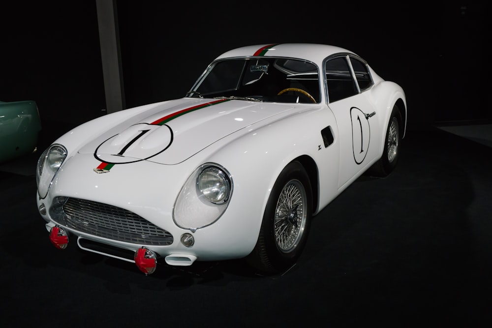 Un auto deportivo blanco en exhibición en una habitación oscura