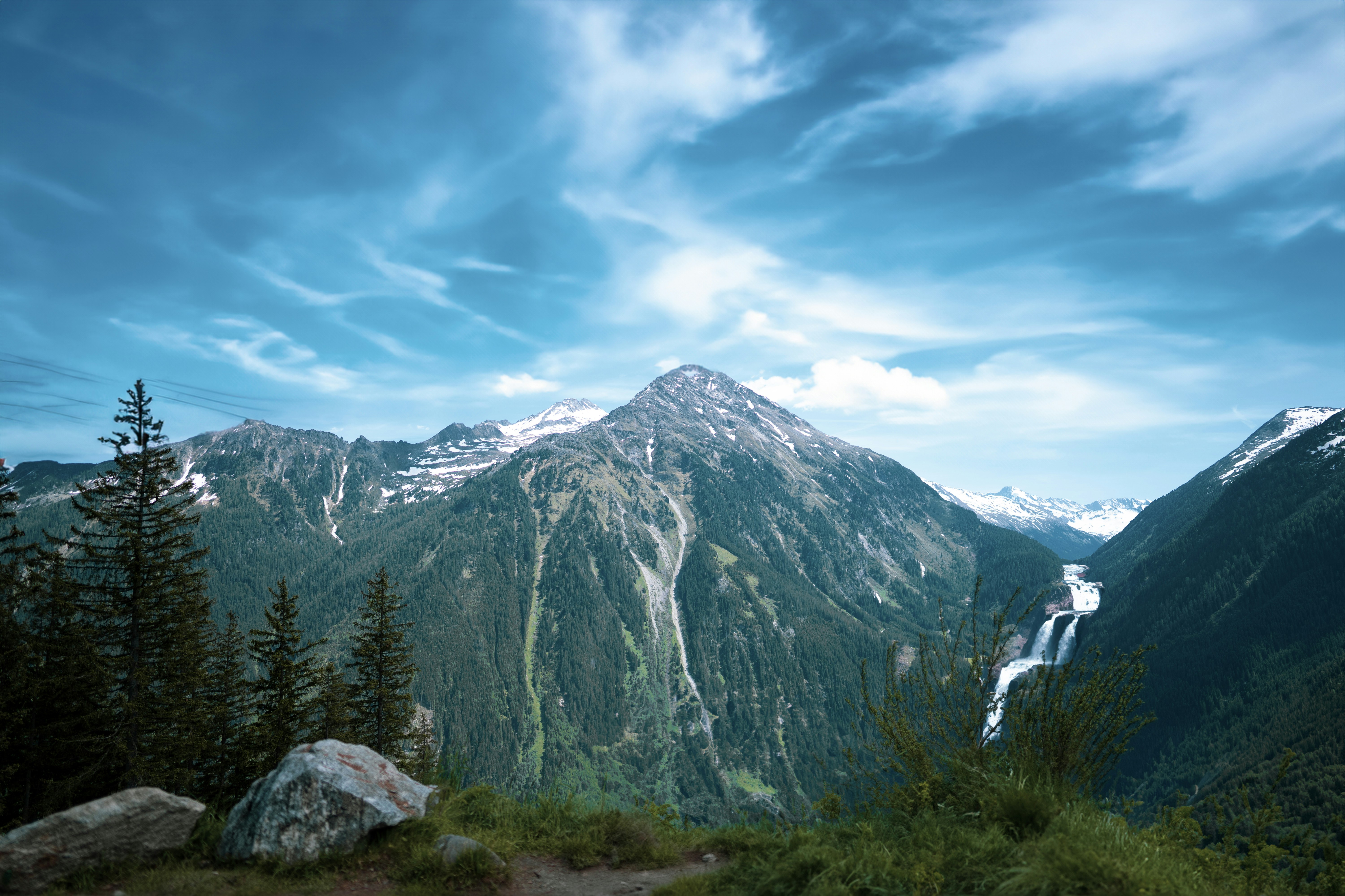 a view of a mountain range with a waterfall in the distance
