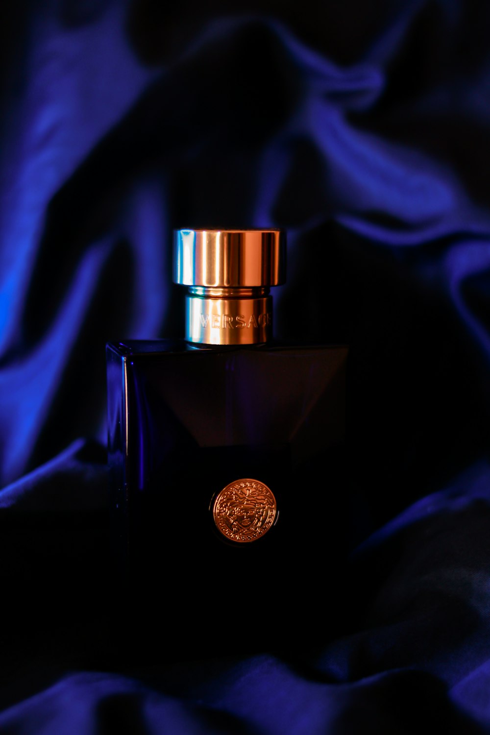 a bottle of perfume sitting on top of a blue cloth