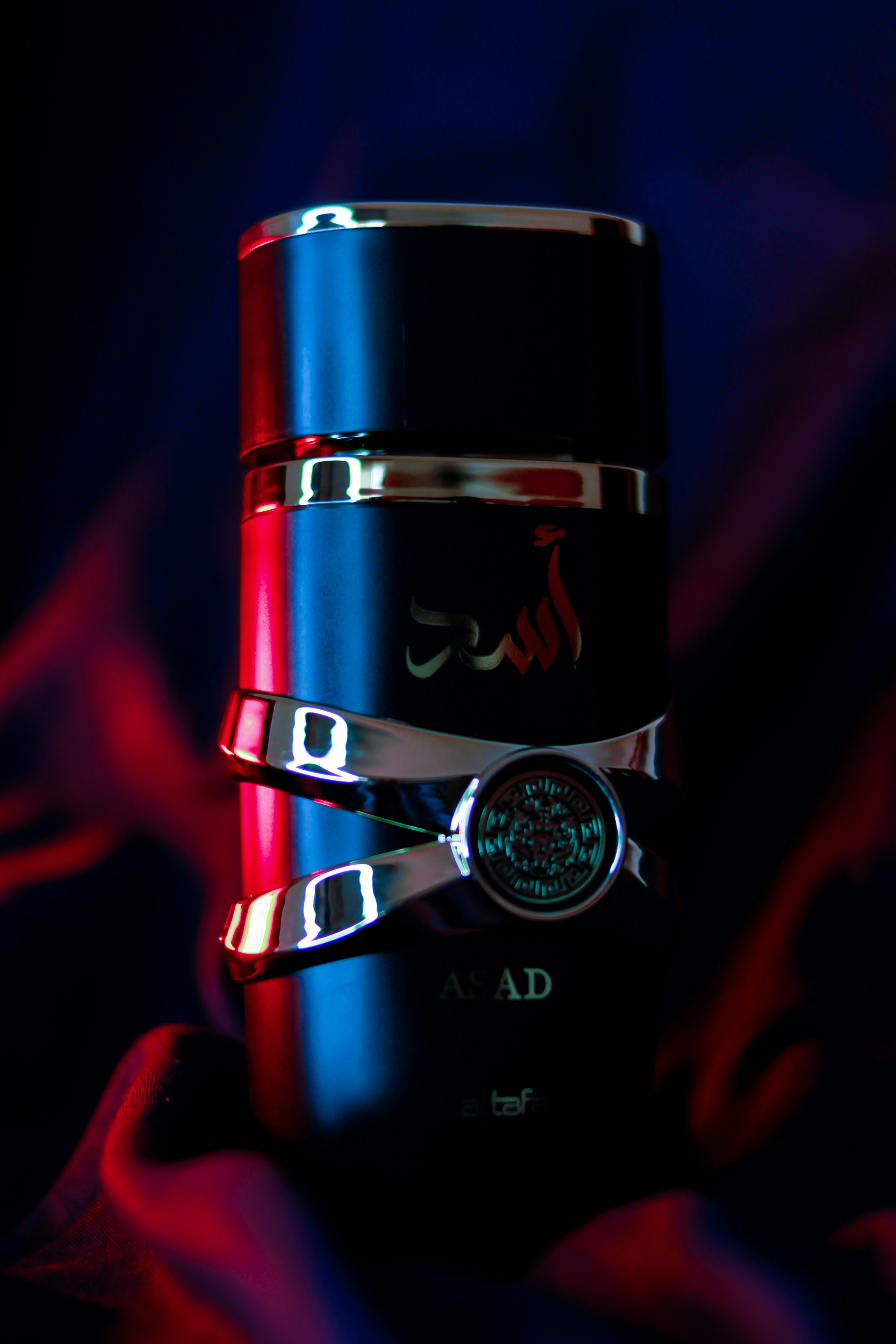 Minimalist black perfume bottle on dark stone, harsh directional light, deep cinematic shadows