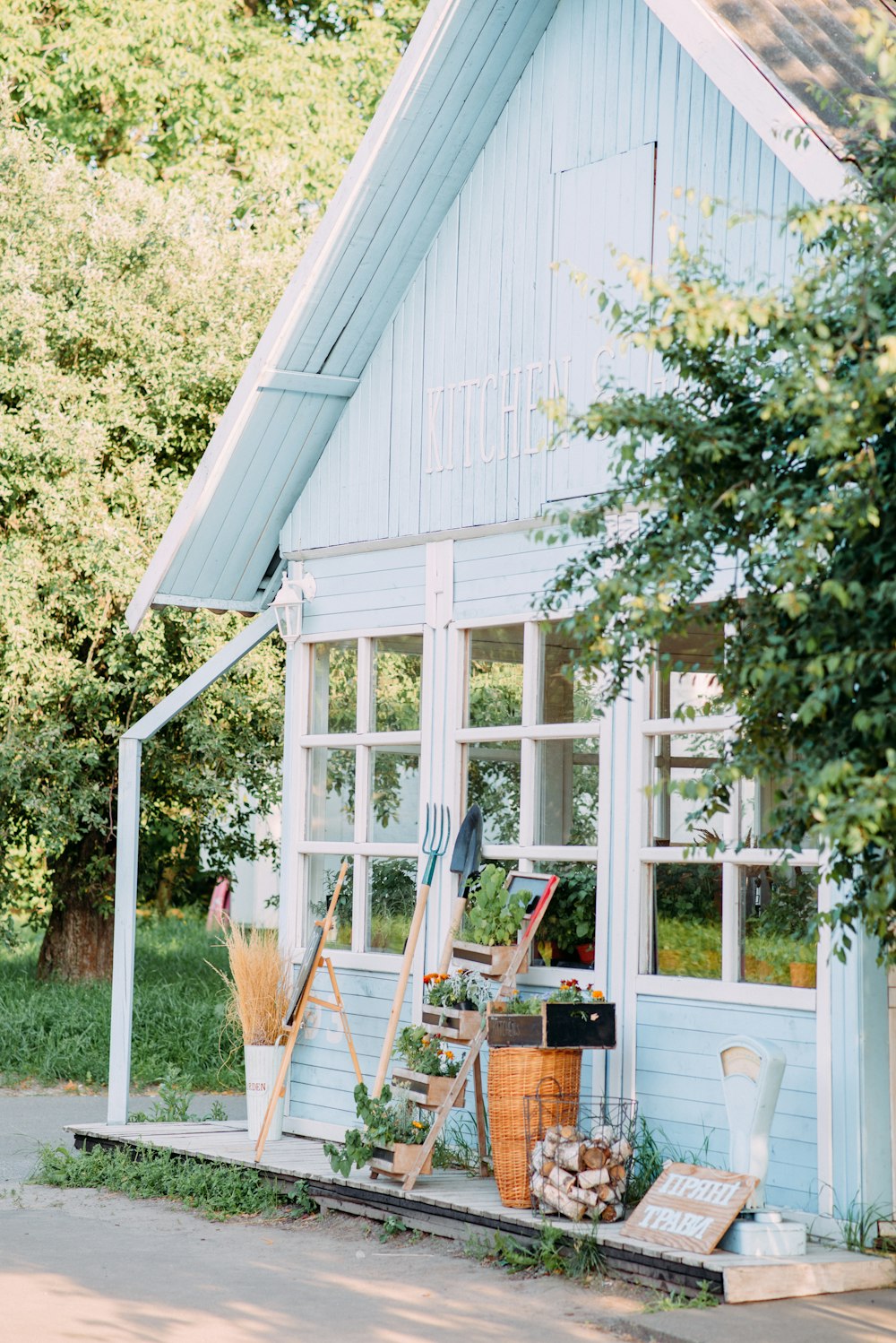 a blue house with lots of plants in front of it