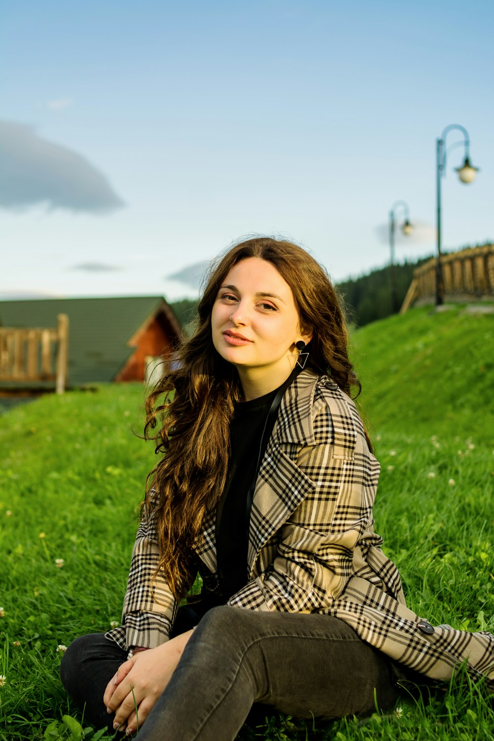 a woman sitting in the grass with her eyes closed