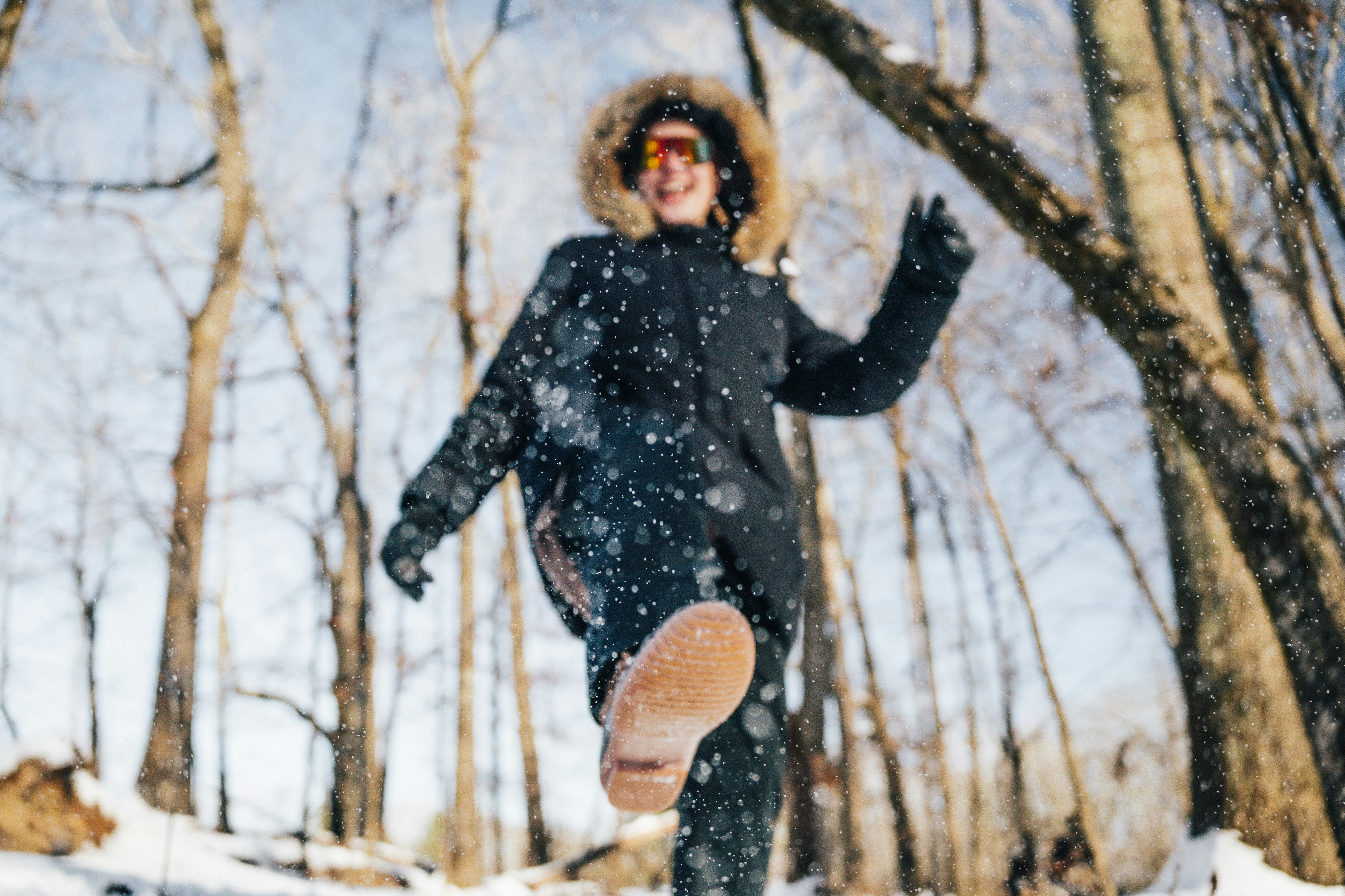 A person running through the snow in the woods photo – Free Grey Image ...