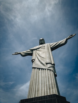a large statue of jesus on top of a hill
