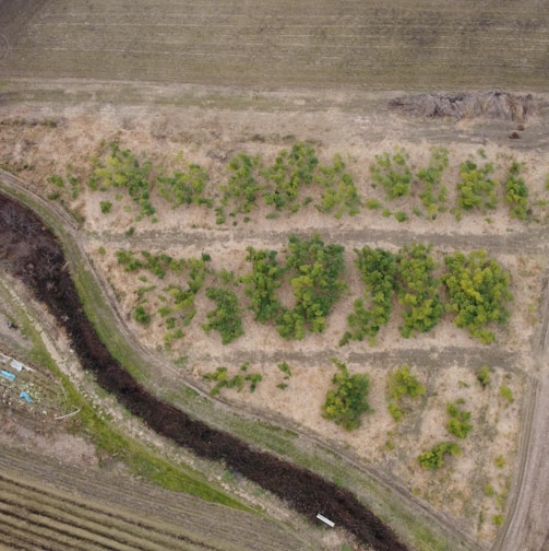 an aerial view of a field with a river running through it