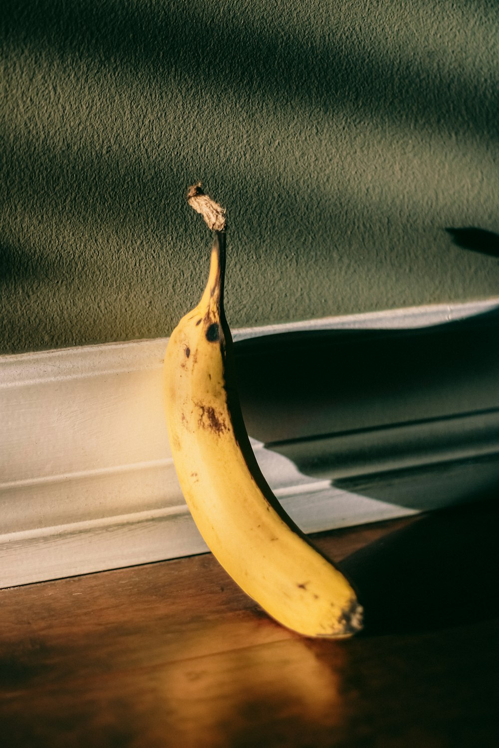 a banana sitting on the floor in front of a window