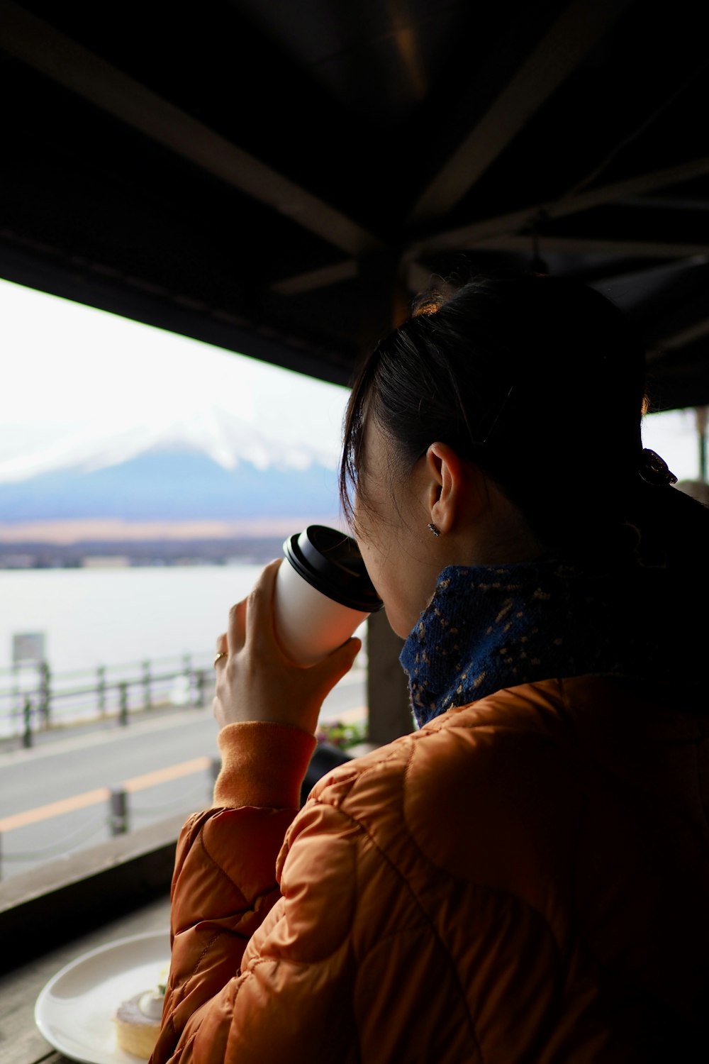 a woman looking out a window at a body of water