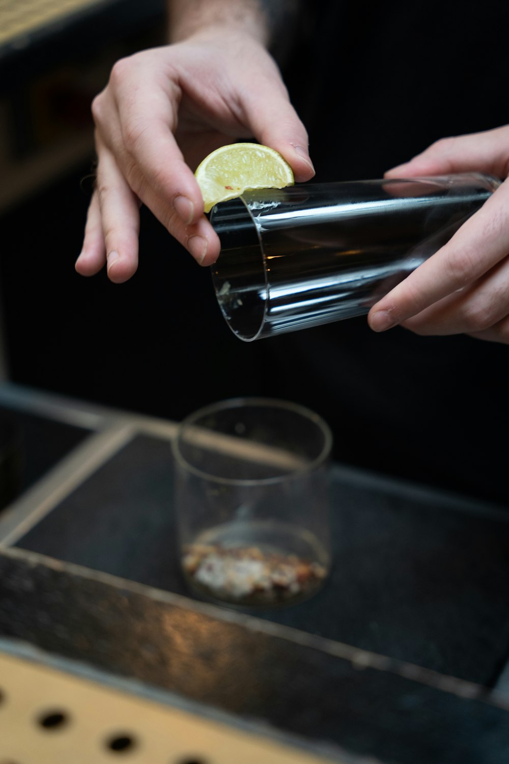 a person pouring a drink into a glass