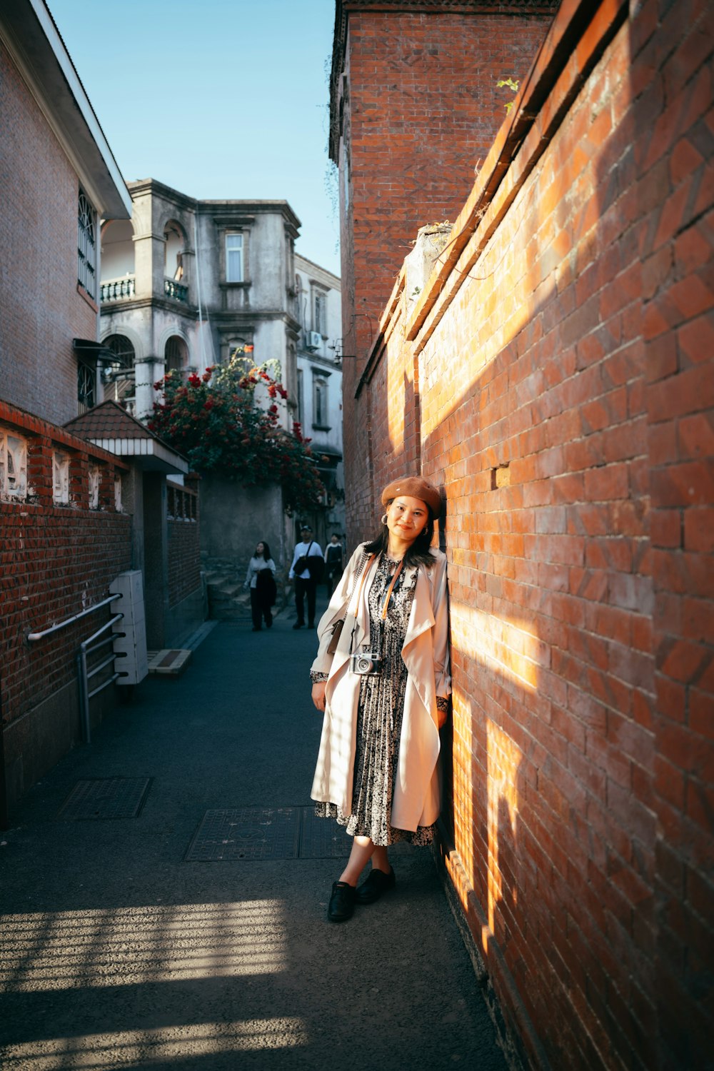 a woman leaning against a brick wall