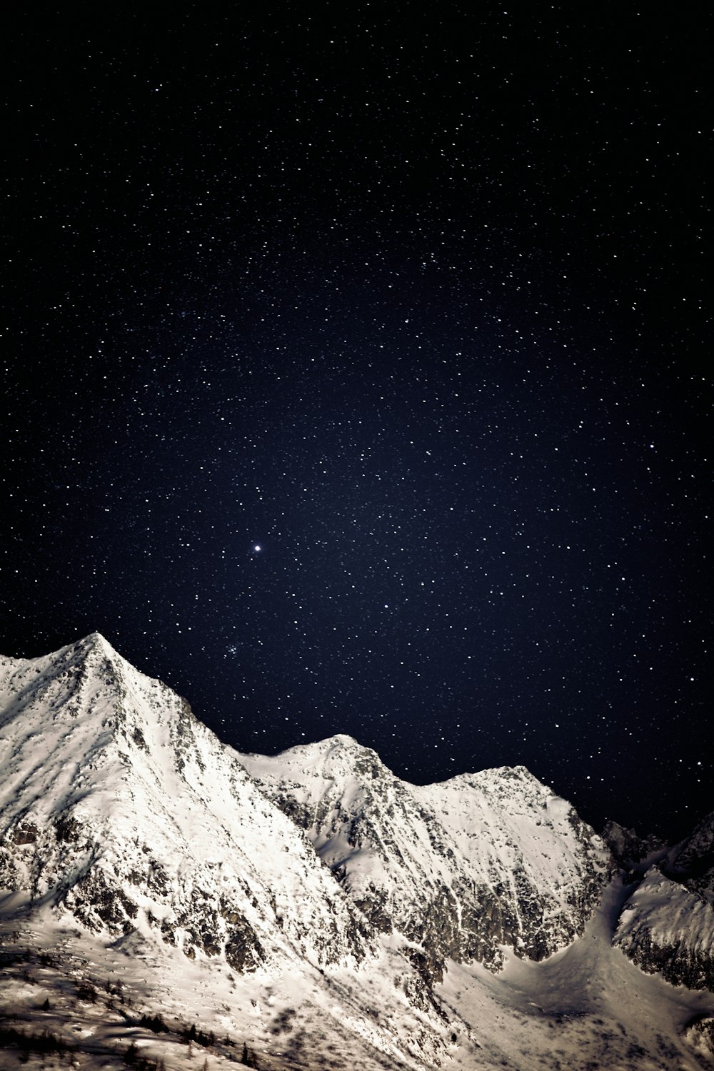 une montagne couverte de neige sous un ciel nocturne