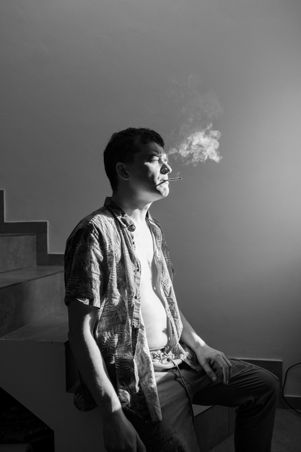 a man sitting down smoking a cigarette