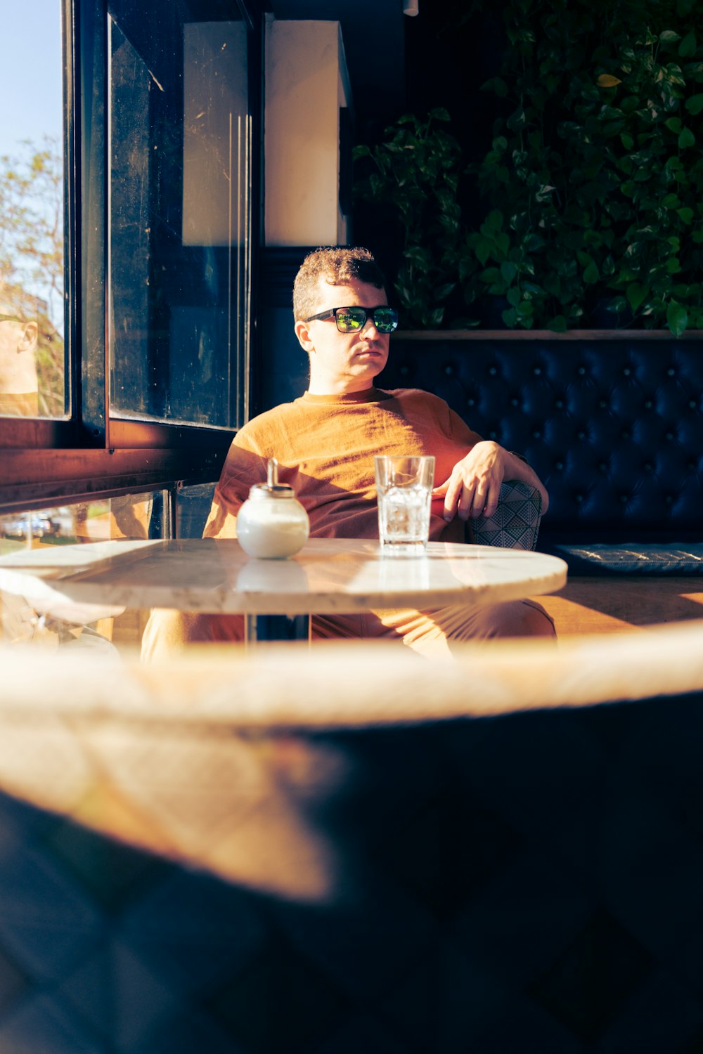 a man sitting at a table with a drink in front of him