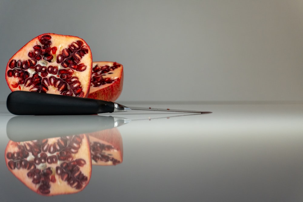 a cut open pomegranate on a reflective surface