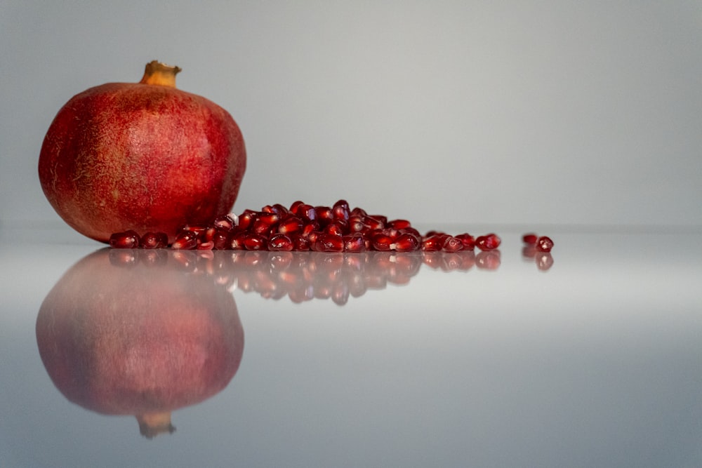 a pomegranate is sitting on a reflective surface