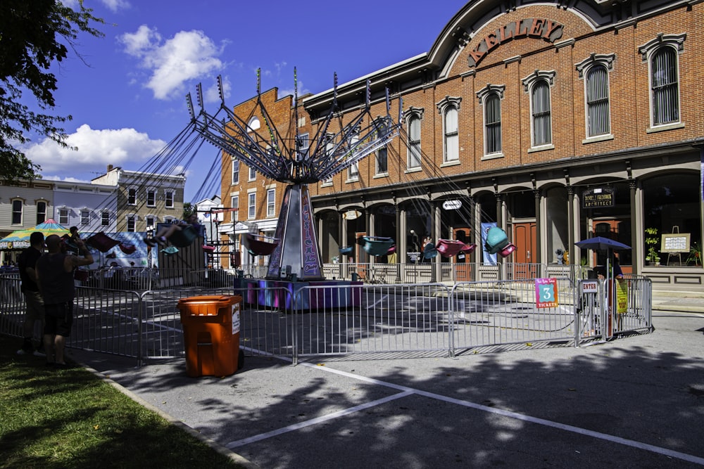 a carousel in front of a building on a sunny day