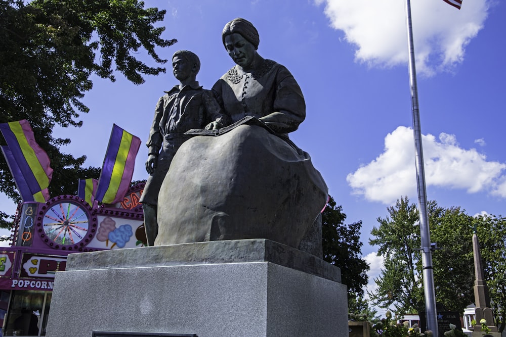 a statue of two people sitting on top of a rock