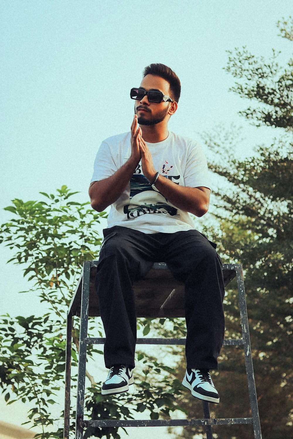 a man sitting on top of a metal step ladder