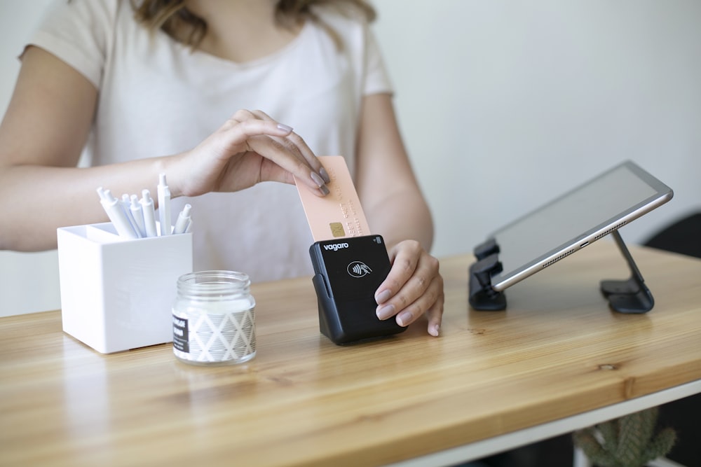 a woman is holding a piece of paper and putting it in a container