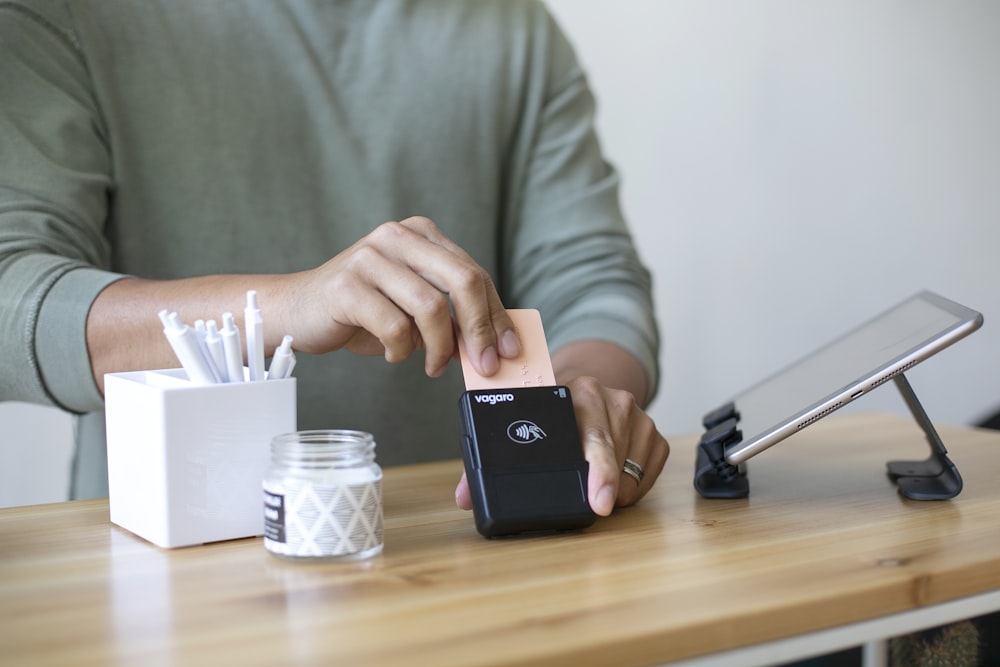 a person sitting at a table with a cell phone