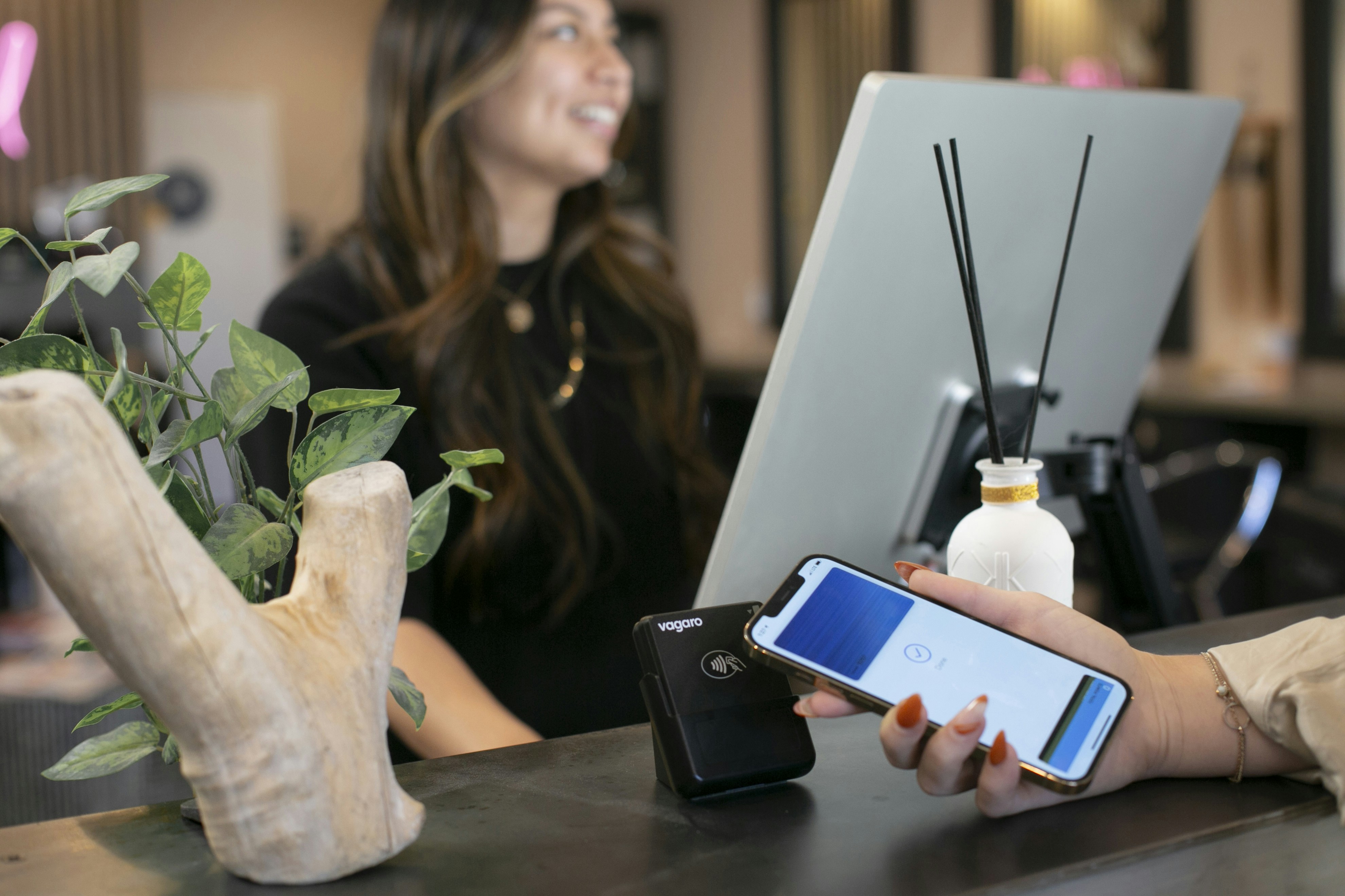 una mujer sentada en un escritorio usando un teléfono celular