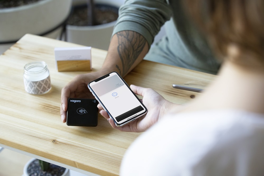 a person sitting at a table with a cell phone