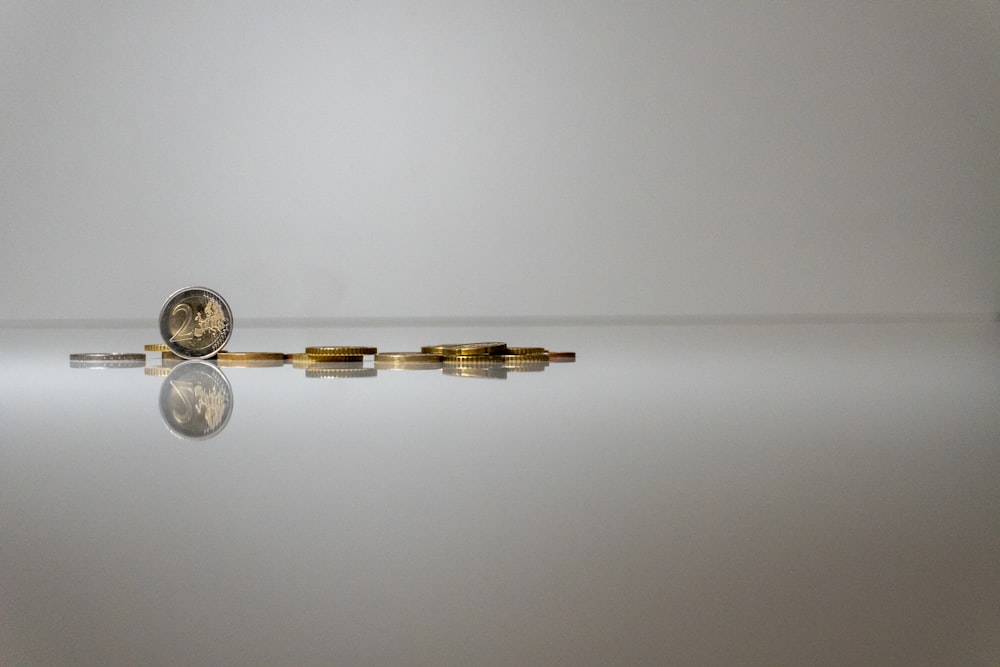 a group of coins sitting on top of a reflective surface
