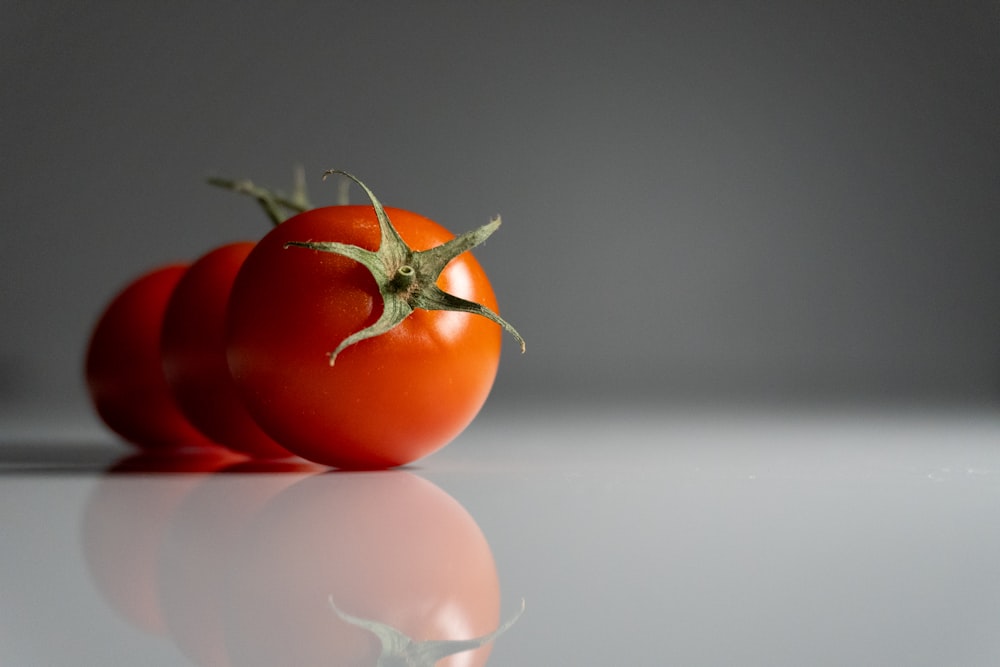um par de tomates sentados em cima de uma mesa