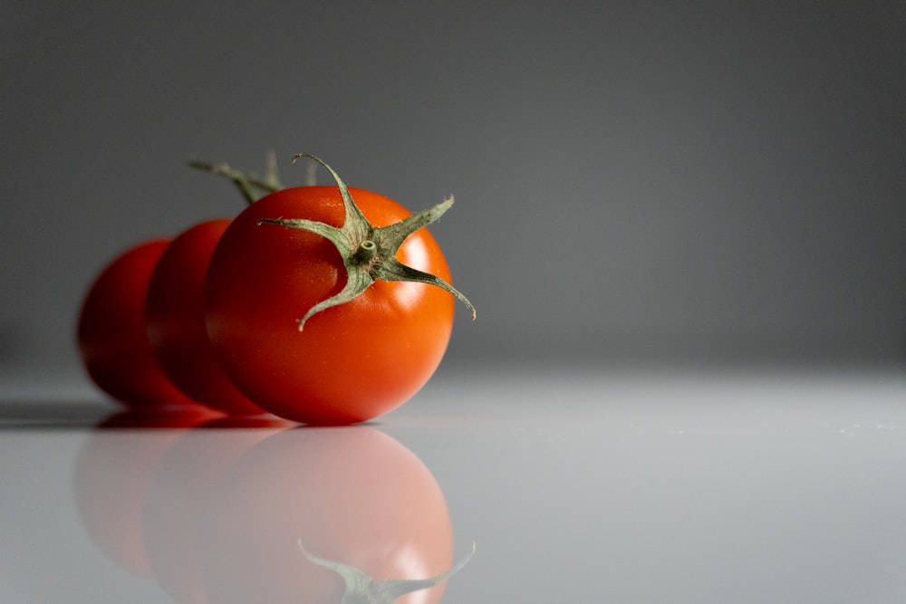 a couple of tomatoes sitting on top of a table