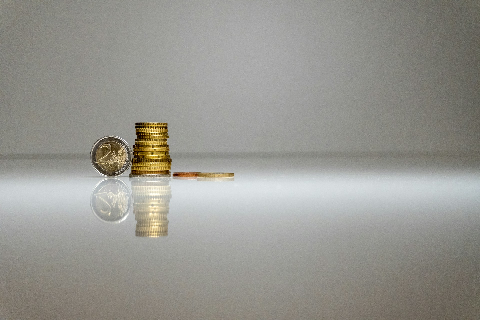 a stack of coins sitting on top of a reflective surface