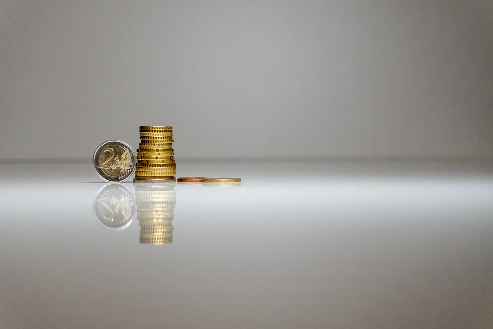 a stack of coins sitting on top of a reflective surface
