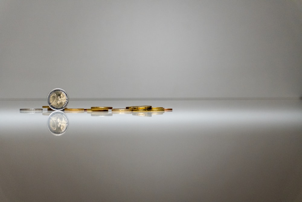 a stack of coins sitting on top of a reflective surface