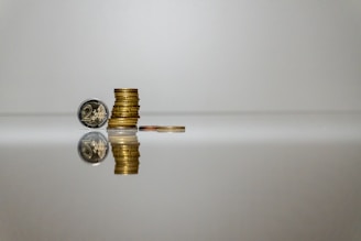 a stack of coins sitting on top of a reflective surface
