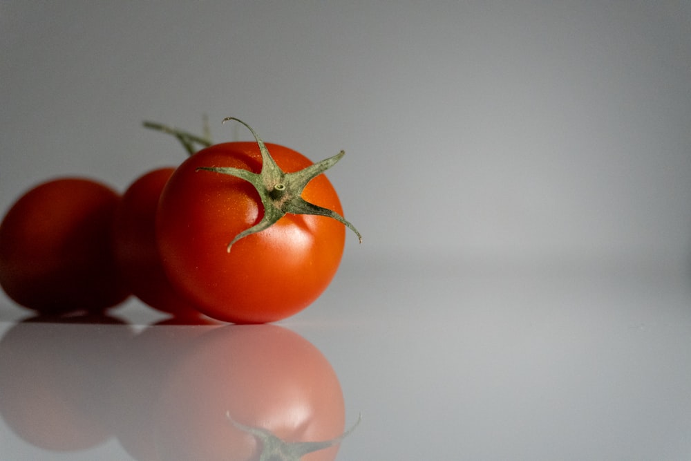 a couple of tomatoes sitting on top of a table