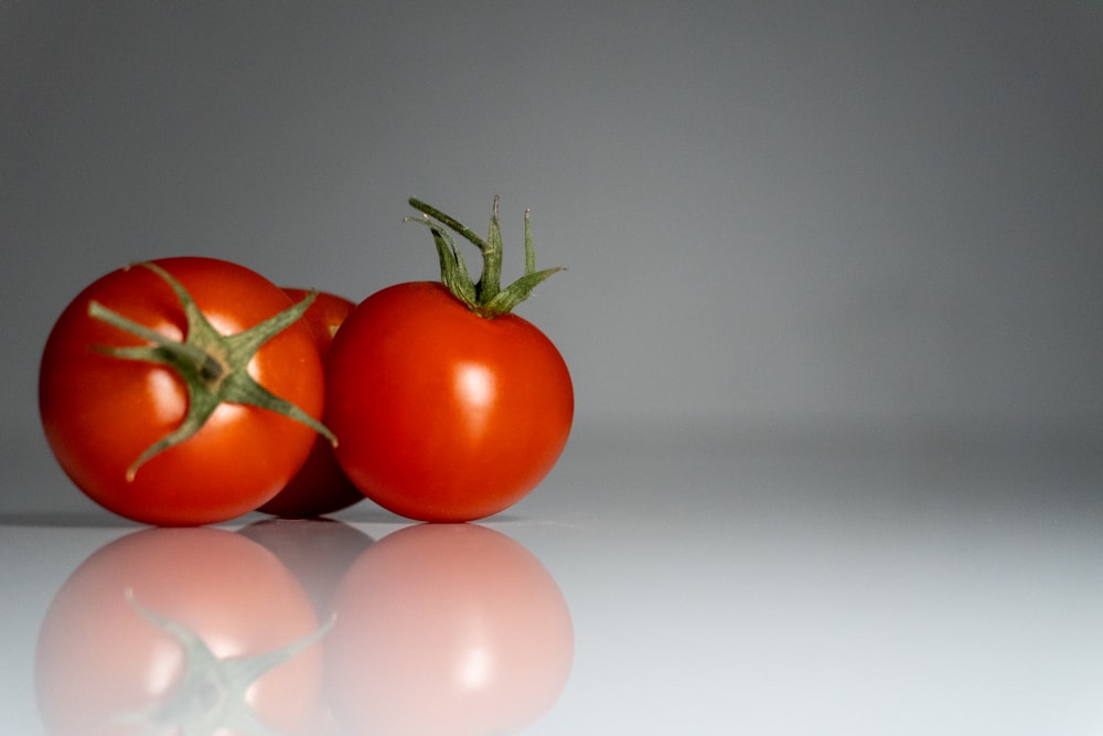 a couple of tomatoes sitting on top of a table