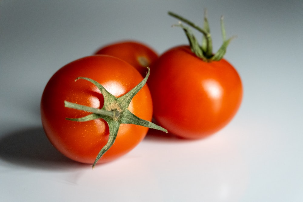 um par de tomates sentados em cima de uma mesa