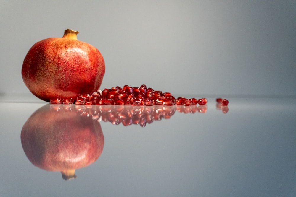 a pomegranate sitting on top of a reflective surface