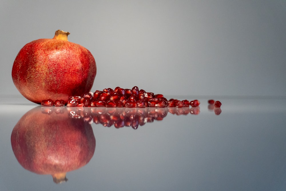Ein Granatapfel sitzt auf einer reflektierenden Oberfläche