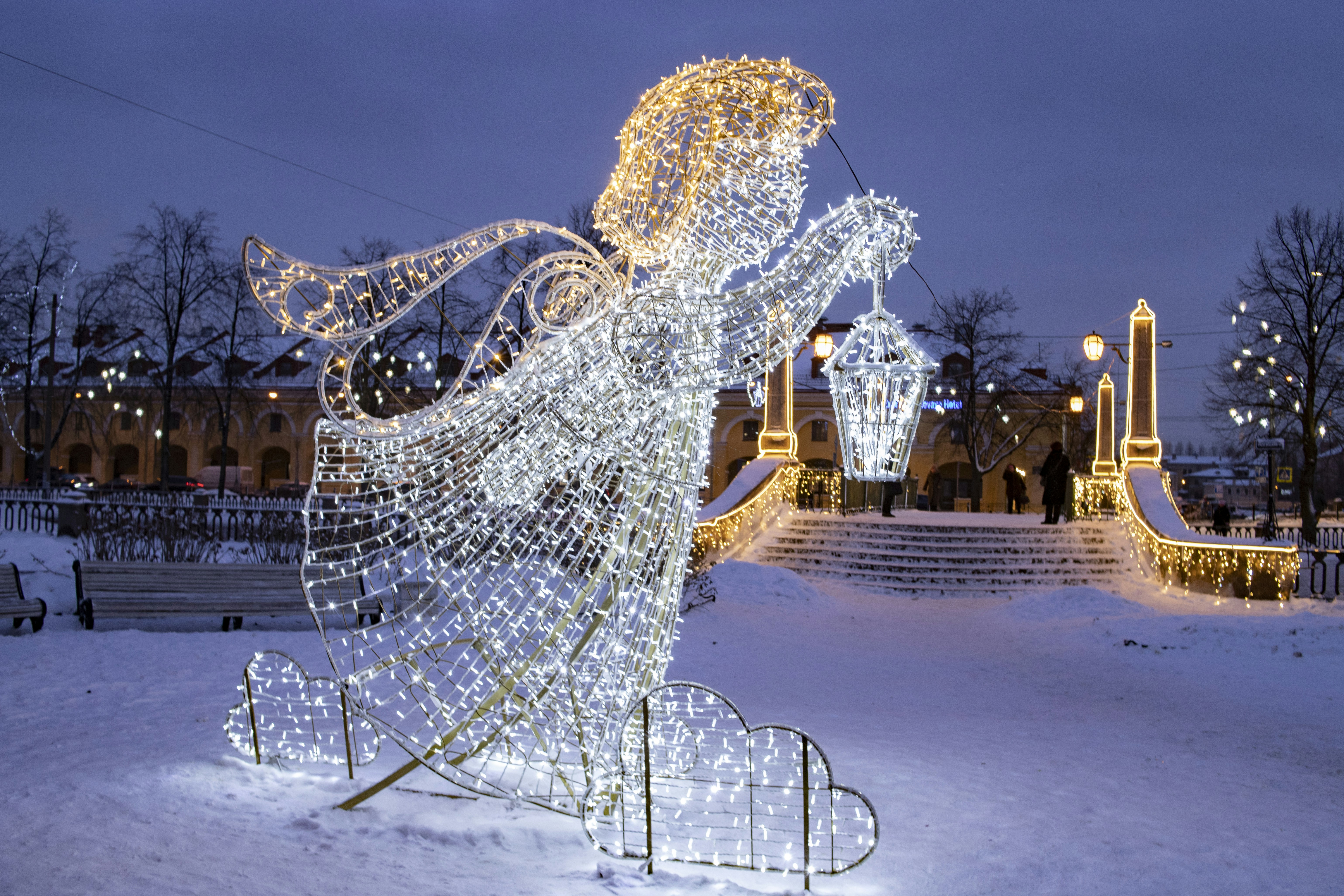 a lighted statue of a woman in the snow