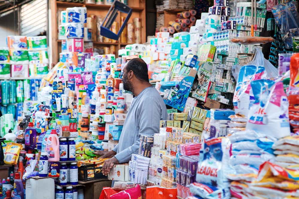 a man standing in front of a store filled with lots of items