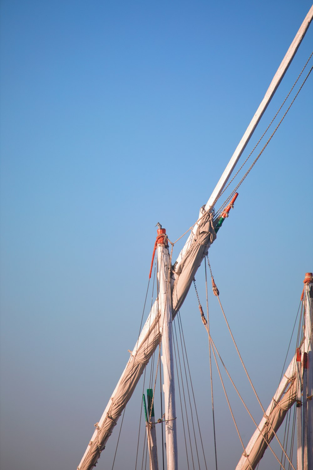 the masts of a sailboat against a blue sky