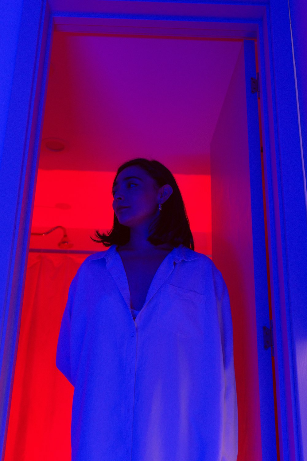 a woman standing in a room with a red and blue light